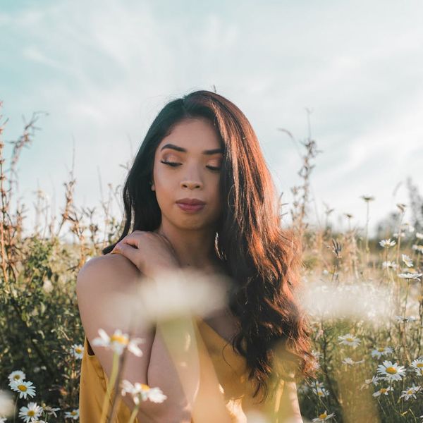 Person sitting peacefully in a meditation pose in a calm environment.
